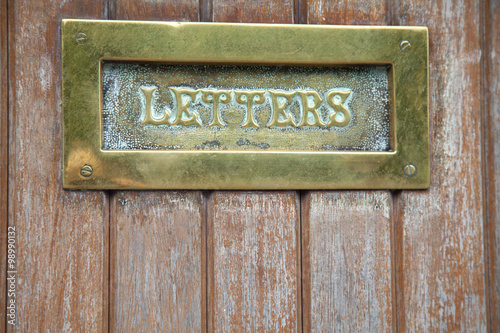 Brass letterbox in wooden door