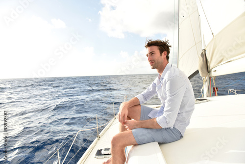 Photography Handsome man relaxing on saiboat in middle of the sea