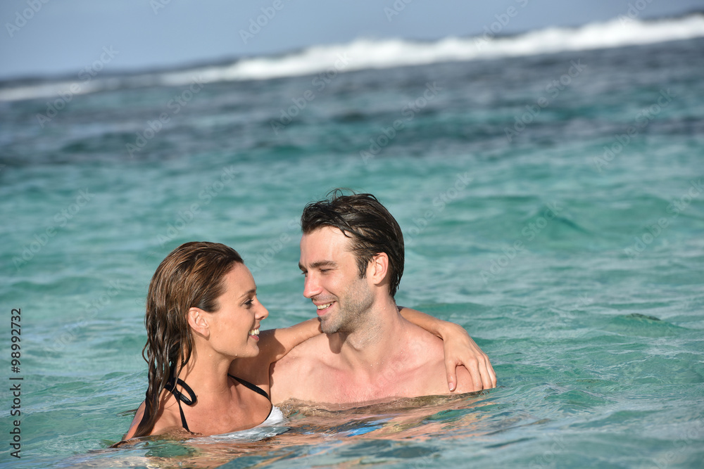 Cheerful couple enjoying sea bath in Caribbean island Cheerful couple enjoying sea bath in Caribbean island