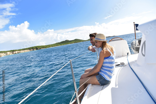 Couple sitting on sailboat deck looking at scenery
