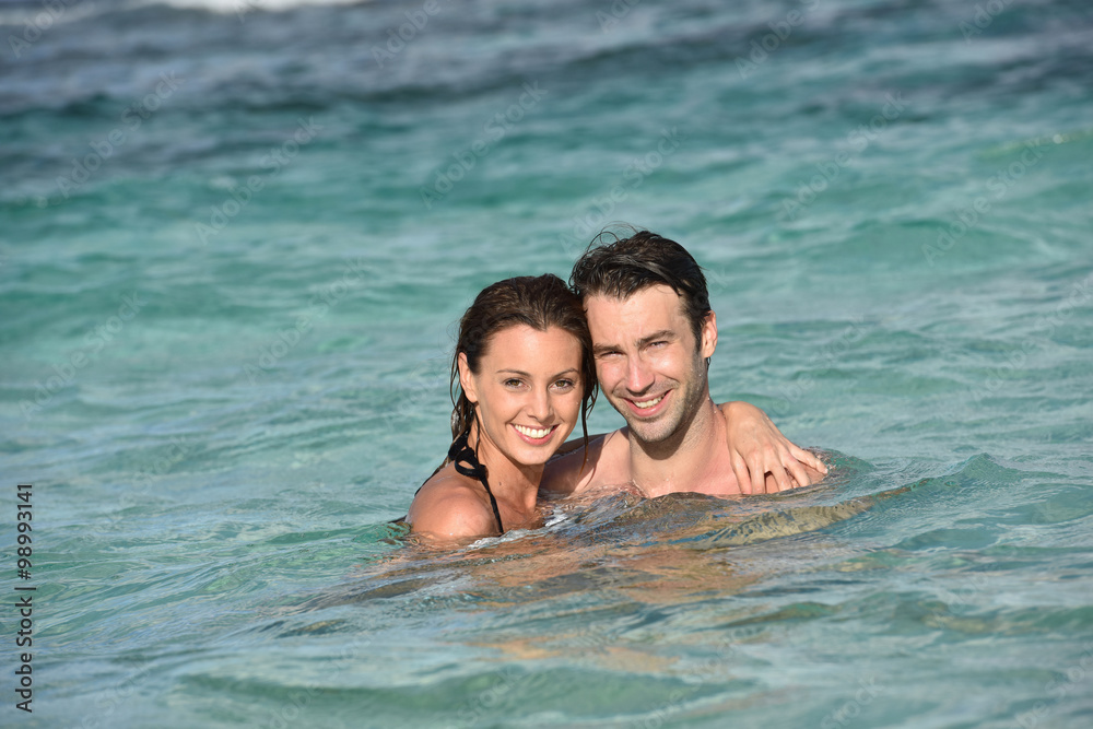 Cheerful couple enjoying sea bath in Caribbean island