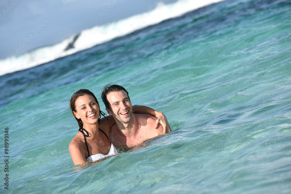 Cheerful couple enjoying sea bath in Caribbean island Cheerful couple enjoying sea bath in Caribbean island