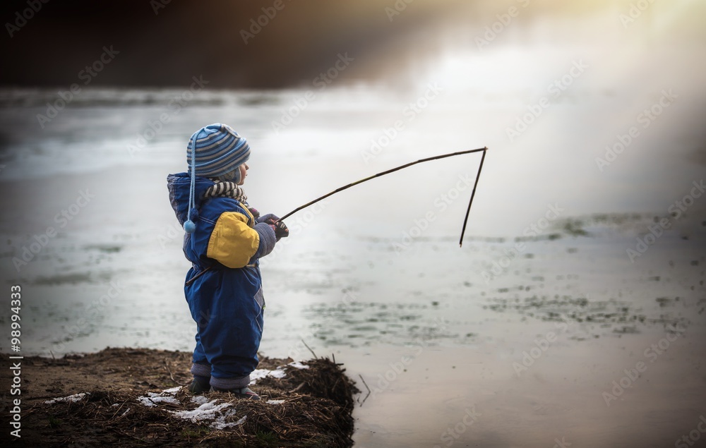 Little boy playing outdoor on frozen lake shore. Little boy playing outdoor on frozen lake shore.