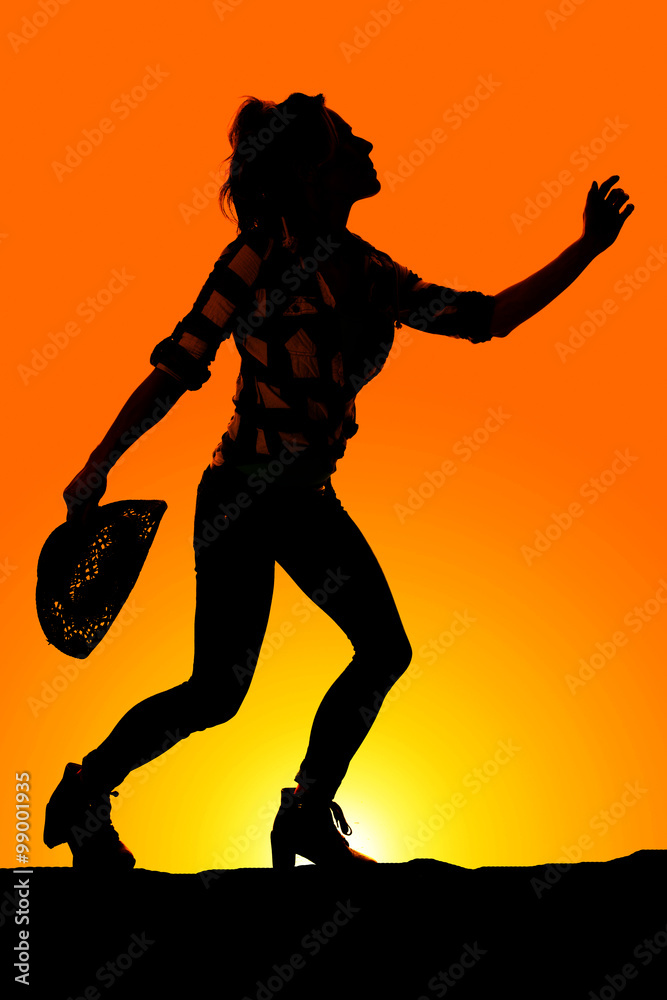 Obraz premium silhouette of a woman with her hat in hand reaching up