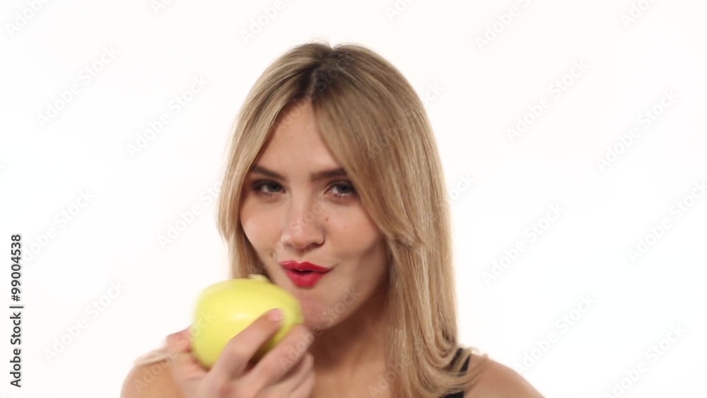 Beauty woman eating fresh and juicy apple at white background Beauty woman eating fresh and juicy apple at white background