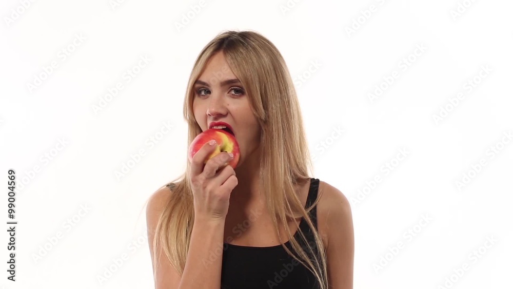 Beauty woman eating fresh and juicy apple at white background Beauty woman eating fresh and juicy apple at white background