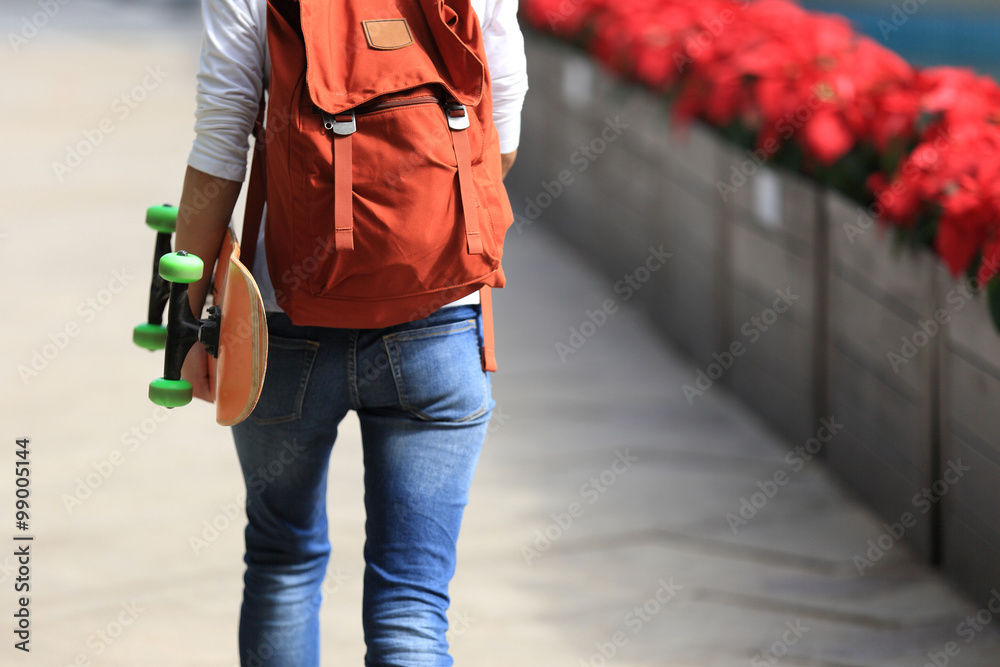 young woman skateboarder walking with skateboard young woman skateboarder walking with skateboard