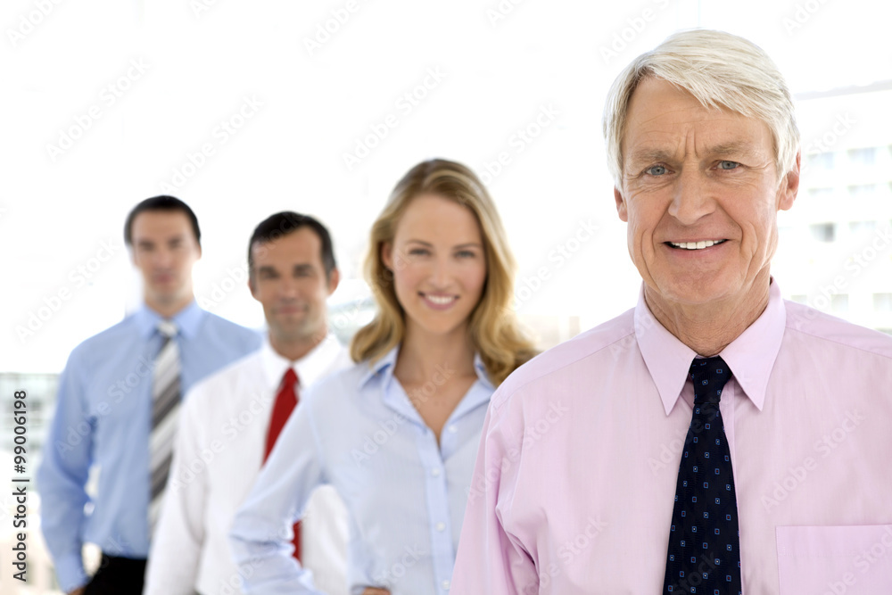 Business people standing in a row with senior leader on foreground. Business people standing in a row with senior leader on foreground.