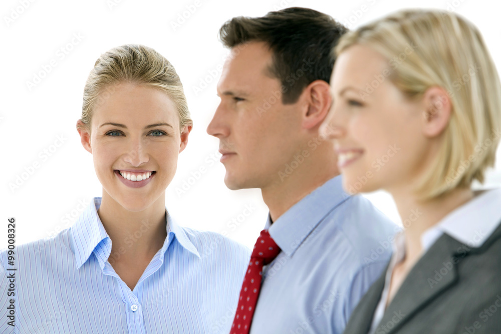 Caucasian business team. Three young business partners standing in a row. Focus on woman looking at camera Caucasian business team. Three young business partners standing in a row. Focus on woman looking at camera