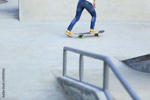 young skateboarder legs skateboarding at skatepark