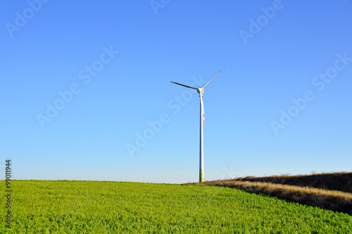 Windkraftanlage mit Feld und blauem Himmel