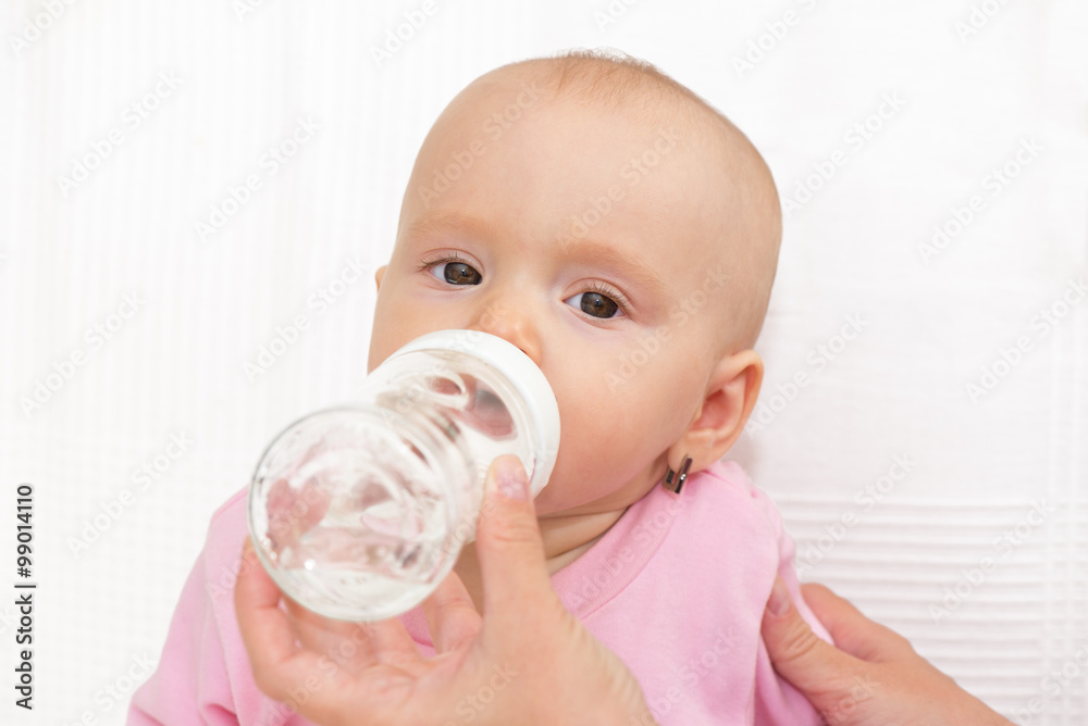 Baby eating from milk bottle, isolated Baby eating from milk bottle, isolated