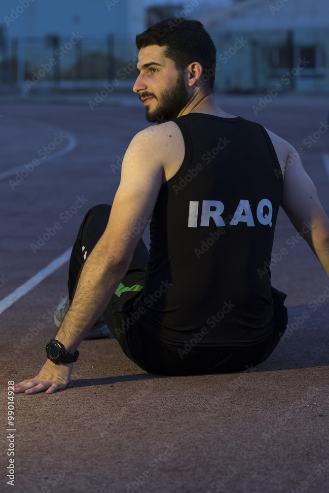 Iraqi athletic sitting on ground of old stadium in Kirkuk city