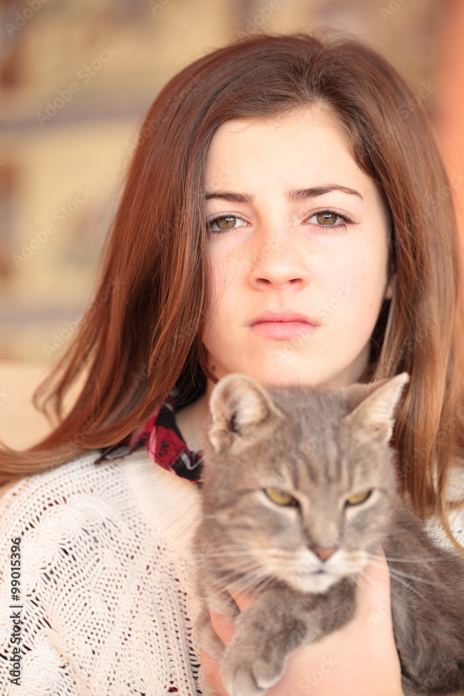 Teenager with her cat in her arms
