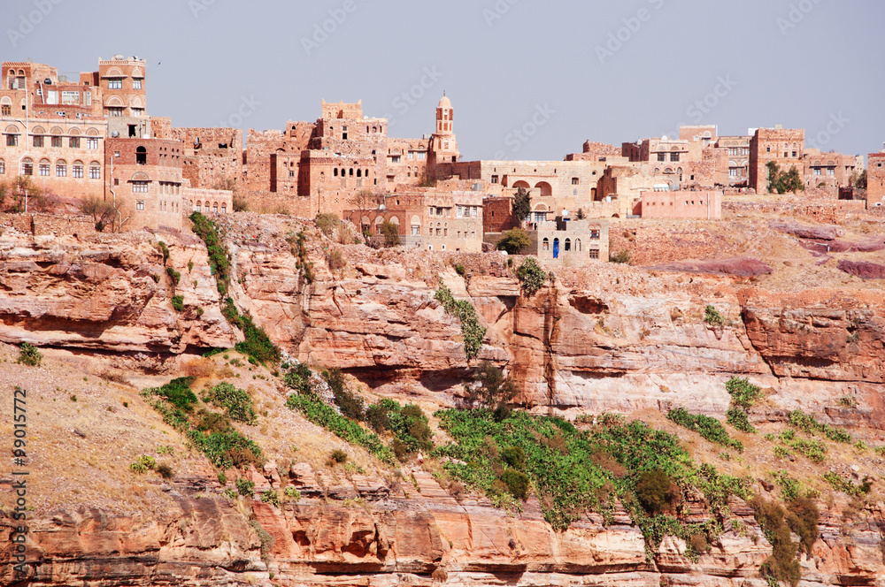 Rocce rosse, montagna, le antiche mura e le case decorate della città fortificata di Kawkaban, Yemen