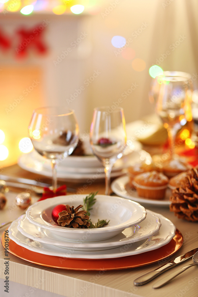 Christmas table setting with holiday decorations on fireplace background