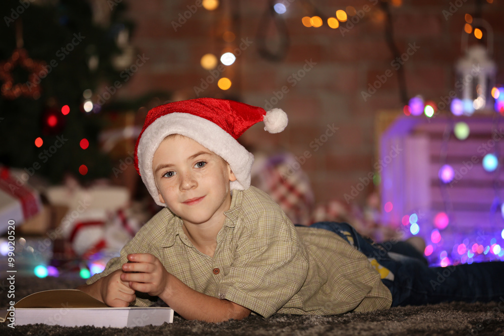 Little boy writing in notebook on a Christmas background Little boy writing in notebook on a Christmas background