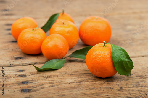 Fresh mandarin oranges fruit with leaves in old wooden table