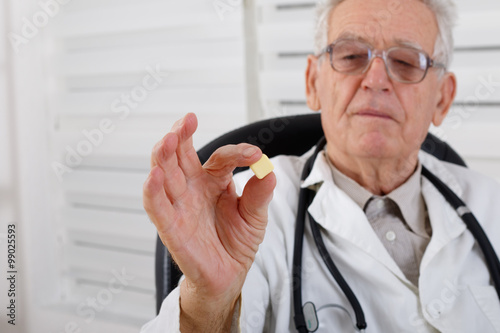 Old doctor observe yellow pill