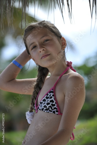 Teenager in swimsuit on the nature under the sun. Blond hair is in plait.