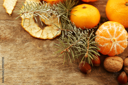 Beautiful still life with tangerines and fir-tree, on old wooden table, close up