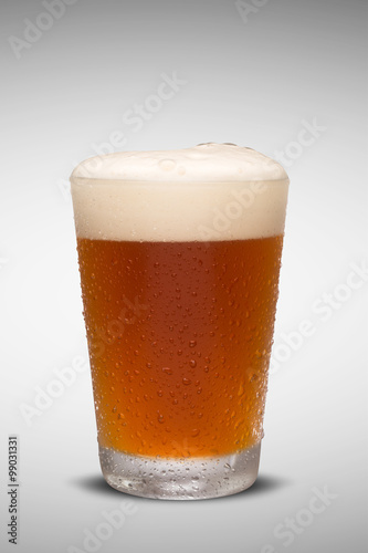 Glass of fresh beer with cap of foam isolated on white backgroun