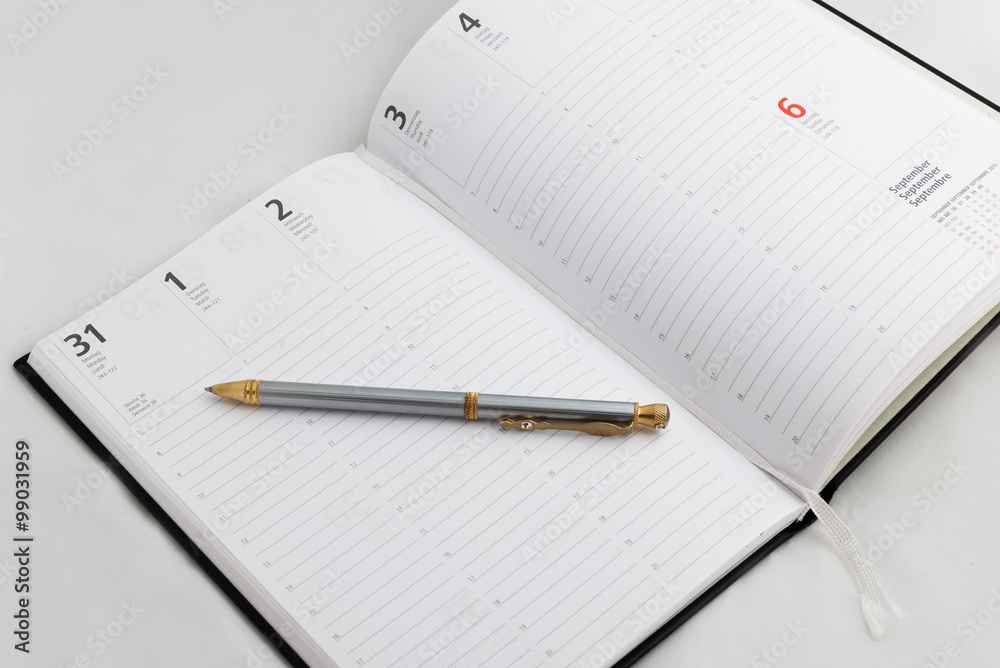 Conceptual,notebook on a white table. open diary and pen Conceptual,notebook on a white table. open diary and pen