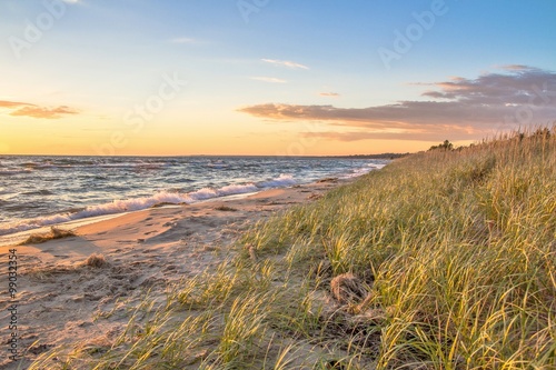 Summer Beach Background.  Remote beach bathed in golden light with sand dunes and dune grass. St. Ignace, Michigan.