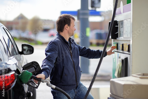 Man filling gasoline fuel in car photo