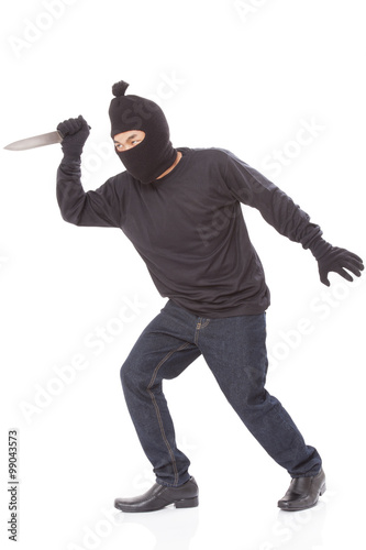 Burglar in mask holding knife on white background © japhoto