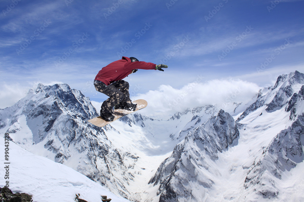 Flying snowboarder on mountains. Extreme sport.