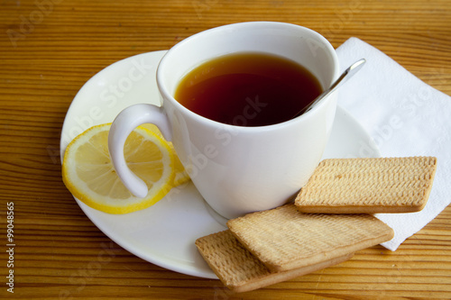 cup on saucer, biscuits and lemon