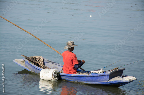 fisherman in fishing boat on water