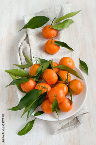 Mandarin with leaves on the white plate