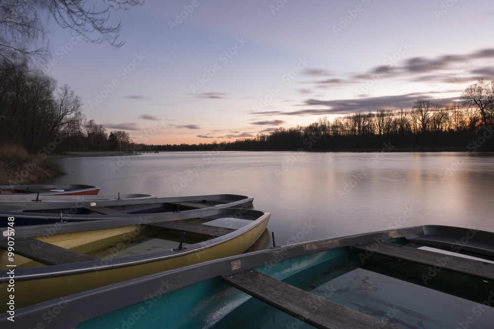 Obraz premium Ruderboote auf See bei Sonnenuntergang
