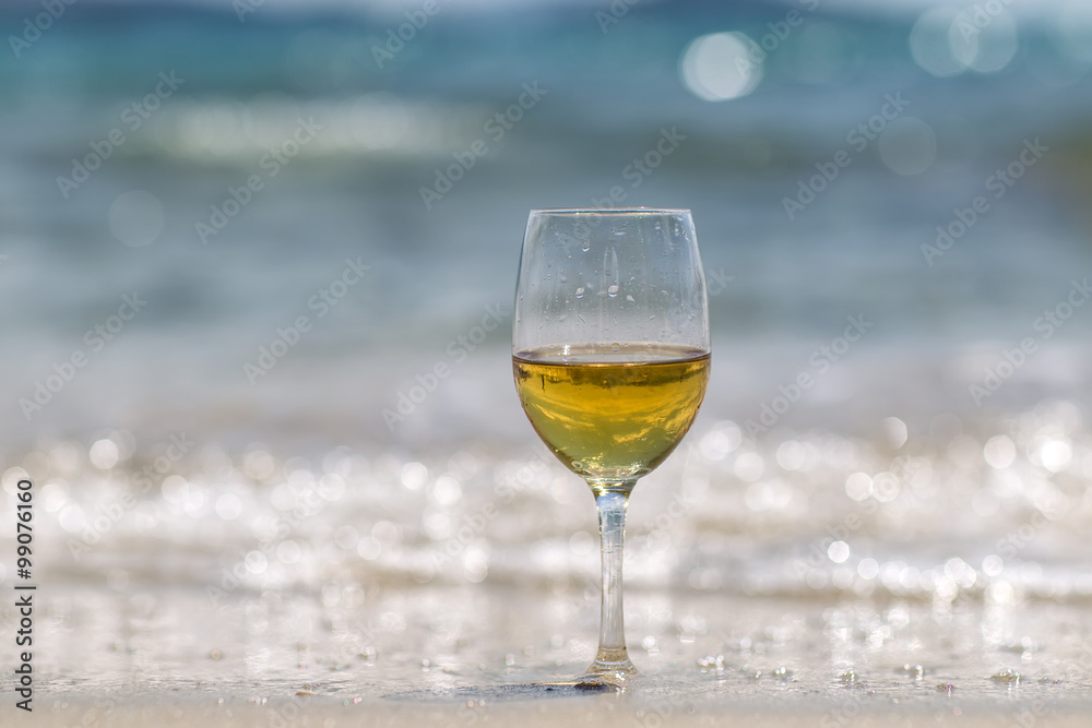 Tall wine glass on sand