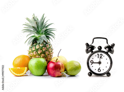 Fresh fruits and alarm clock
