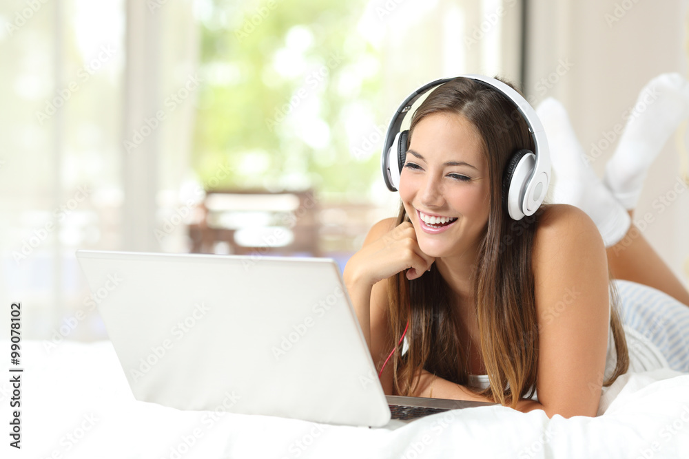 Girl with headphones reading in a laptop at home Girl with headphones reading in a laptop at home