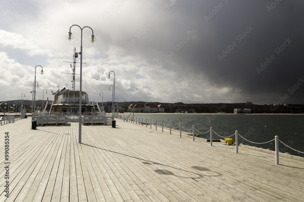 rain passing over a wooden, sea pier