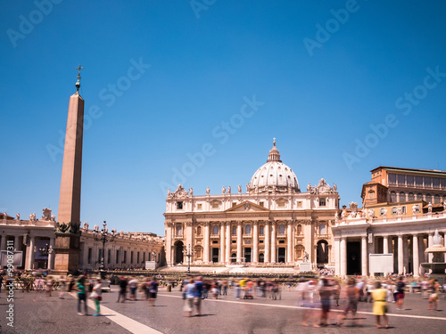 St. Peter’s square in the Vatican City (within Rome, Italy) during a sunny day in June. Long exposure. You see tourists and St. Peter’s Basilica (Papal Basilica of St. Peter in the Vatican). 