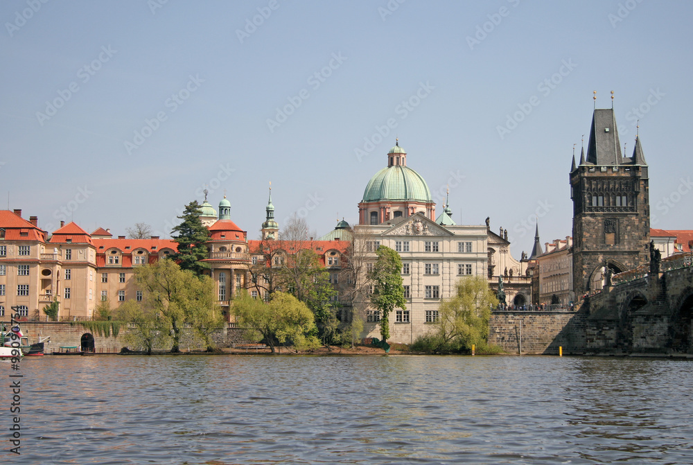 PRAGUE, CZECH REPUBLIC - APRIL 24, 2010: River Vltava in Prague. Old Town tower of Charles bridge and St Francis' of Assisi Church near the river.