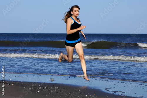 Woman running on the beach barefooted