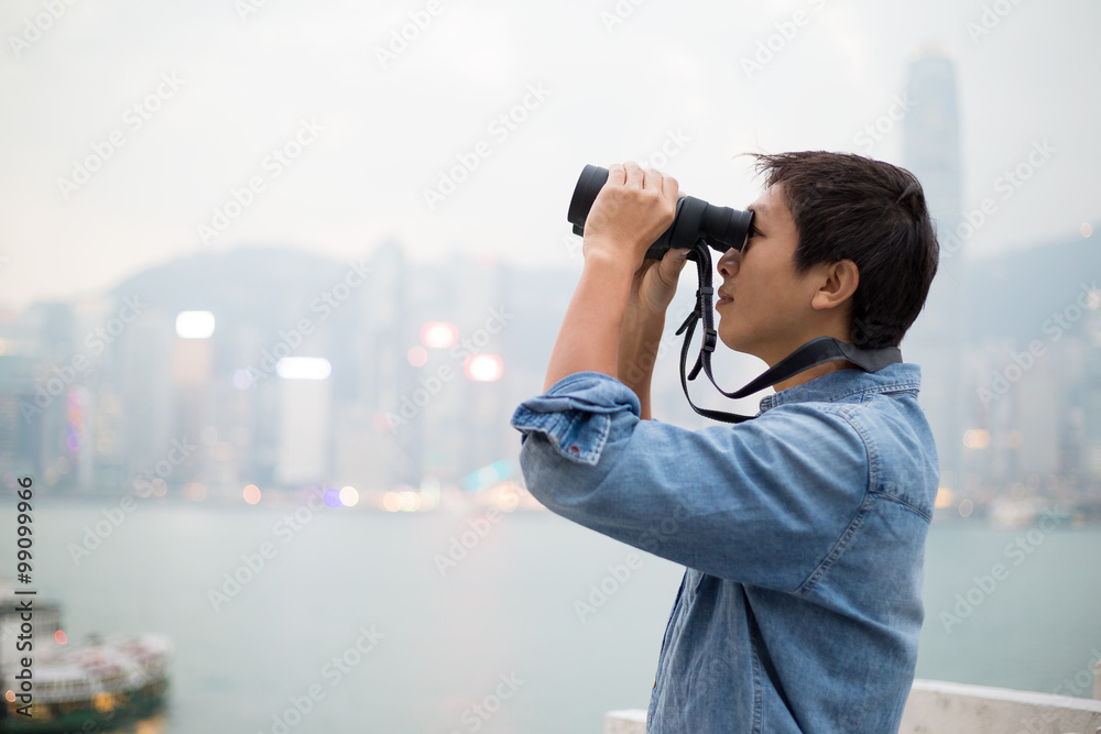 Man looking though binoculars at Hong Kong
