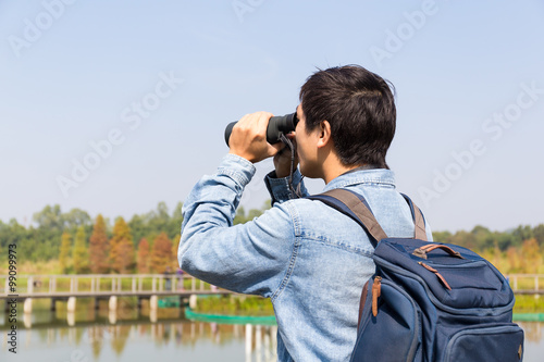 The back rear of man using binoculars for birdwatching photo