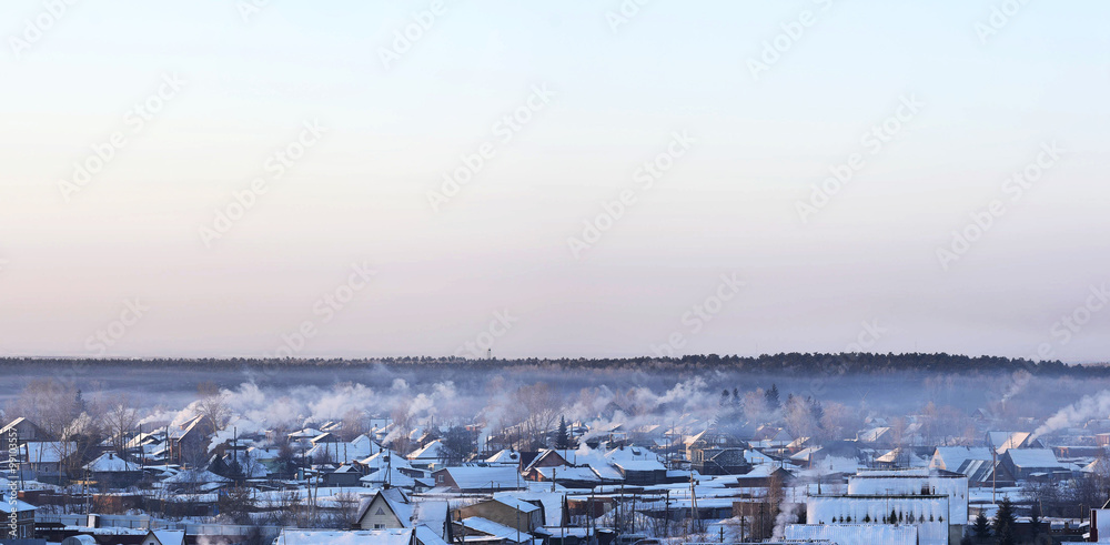 Winter landscape of Siberia with smoking chimneys
