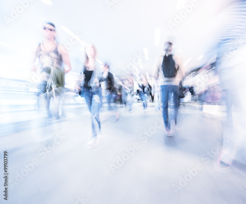 Zoom and motion blurred crowd walking in city