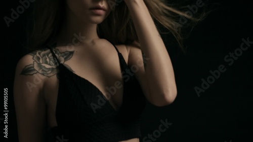 Young woman in lingerie posing on black background