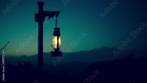 Lantern at twilight with mountains in the background. Cinemagraph seamless loop.