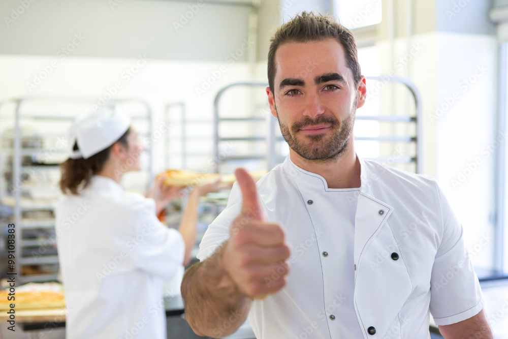 Obraz premium Young attarctive baker working at the bakery