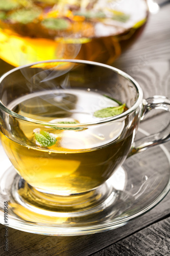 Cup with flower tea and teapot